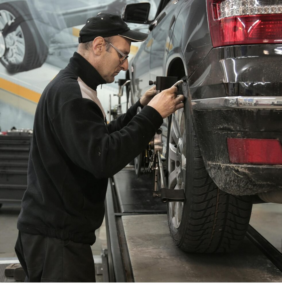 pexels-photo-3806280-3806280 Professional mechanic adjusting wheel alignment for optimal performance in auto repair shop.