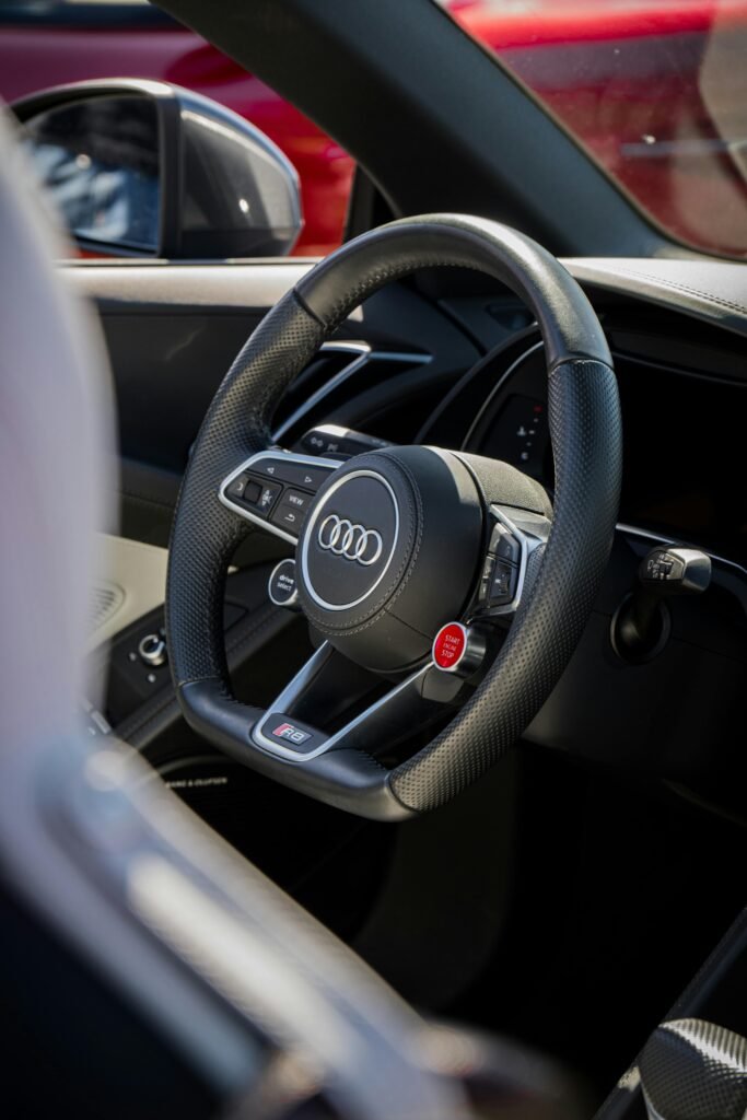 pexels-photo-12862509-12862509 Elegant Audi car interior featuring a premium black leather steering wheel and sleek design.