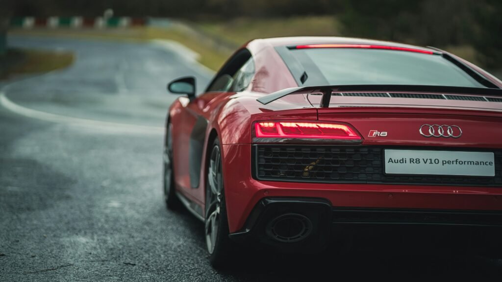pexels-photo-5733734-5733734 A luxury red Audi R8 V10 sports car with spoiler on a wet asphalt road.
